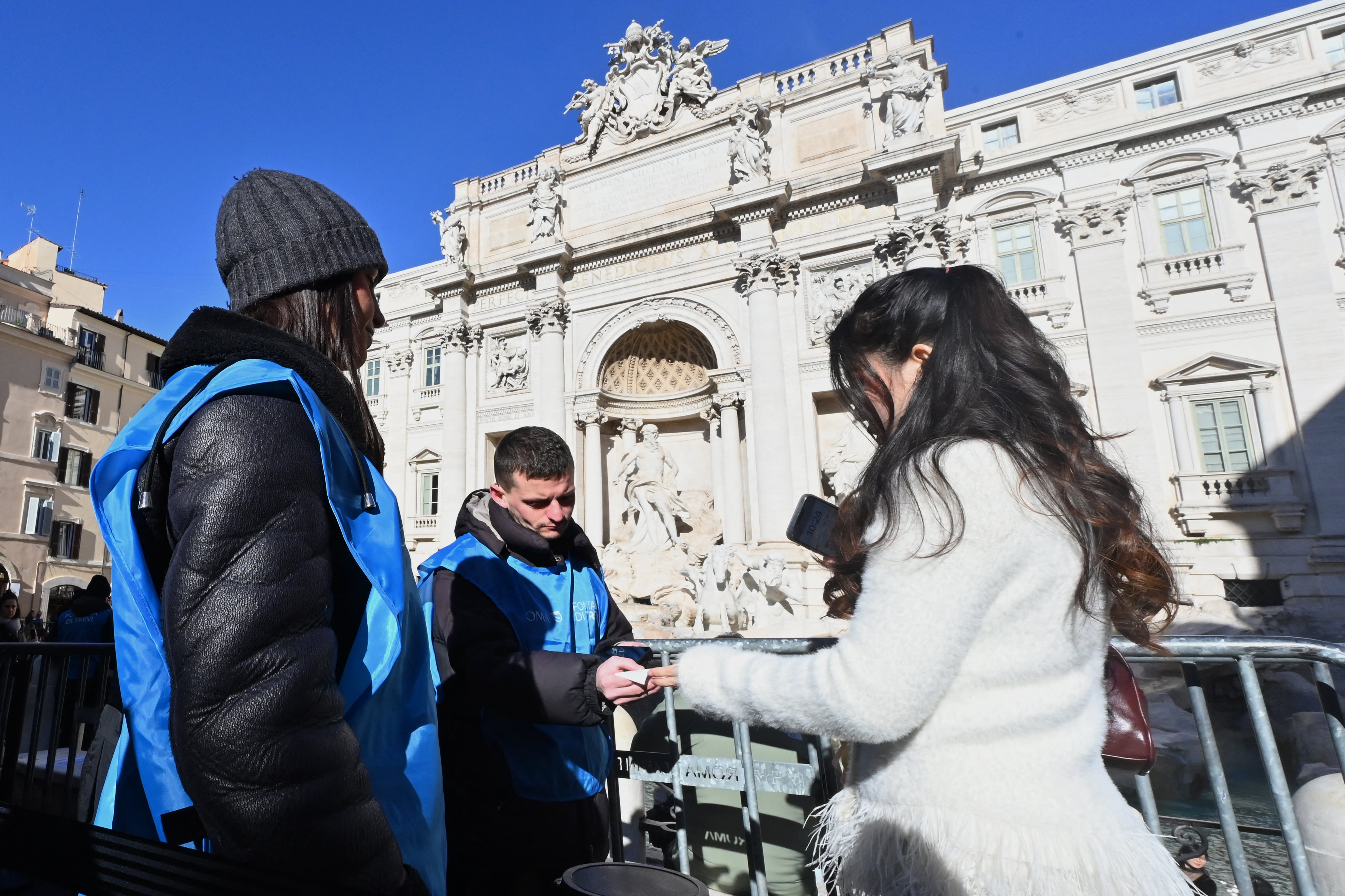 Una turista muestra su entrada de dos euros para acceder al mirador de la Fontana di Trevi en Roma