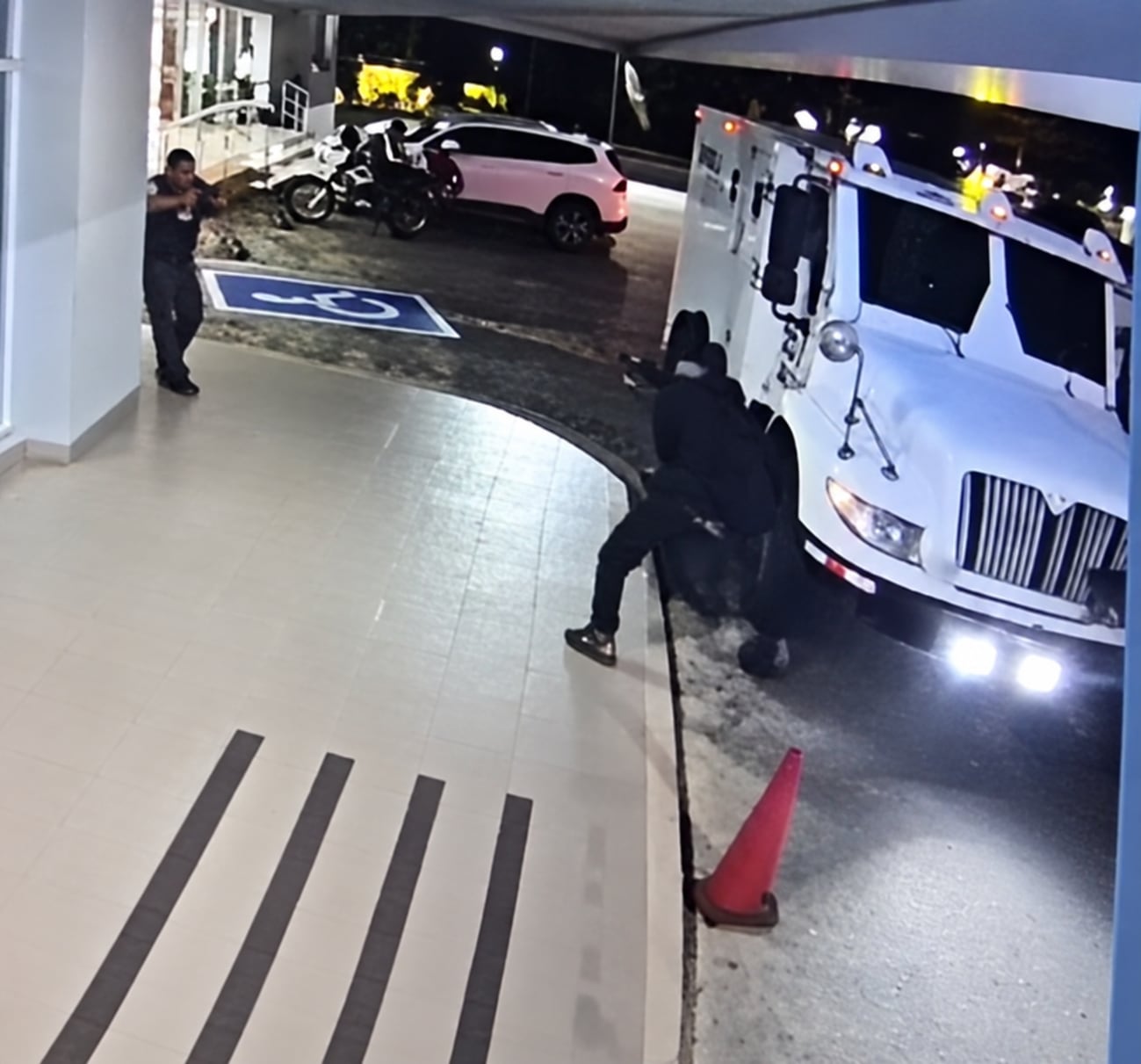 Cámaras de seguridad captaron a tres hombres encapuchados acercándose al camión blindado mientras los custodios realizaban el traslado del dinero. Captura de video