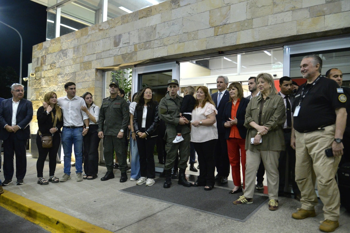 La ministra Patricia Bullrich, acompañada por Nahuel Gallo y Alejandra Monteoliva, participa en un evento junto a personal de seguridad y funcionarios.