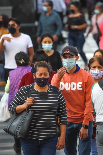 Personas con cubrebocas caminan hoy por el centro histórico de la Ciudad de México (México). EFE/Madla Hartz