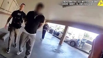 Un oficial de policía, Caleb Schilling, con uniforme negro, escolta a un individuo con rostro borroso en un estacionamiento subterráneo, con sello de cámara corporal