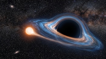 Una estrella anaranjada de menor tamaño orbita un agujero negro de gran escala rodeado por un disco de gas y polvo, con estrellas de fondo.