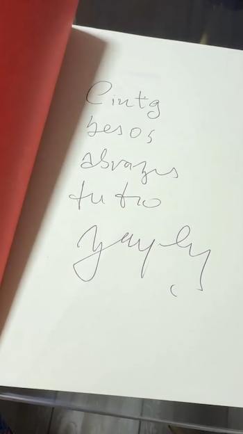 Página de un libro con texto manuscrito y una firma en tinta negra. Se lee 'Cintg', 'besos', 'abrazos', 'tu tio' y 'Bayly'