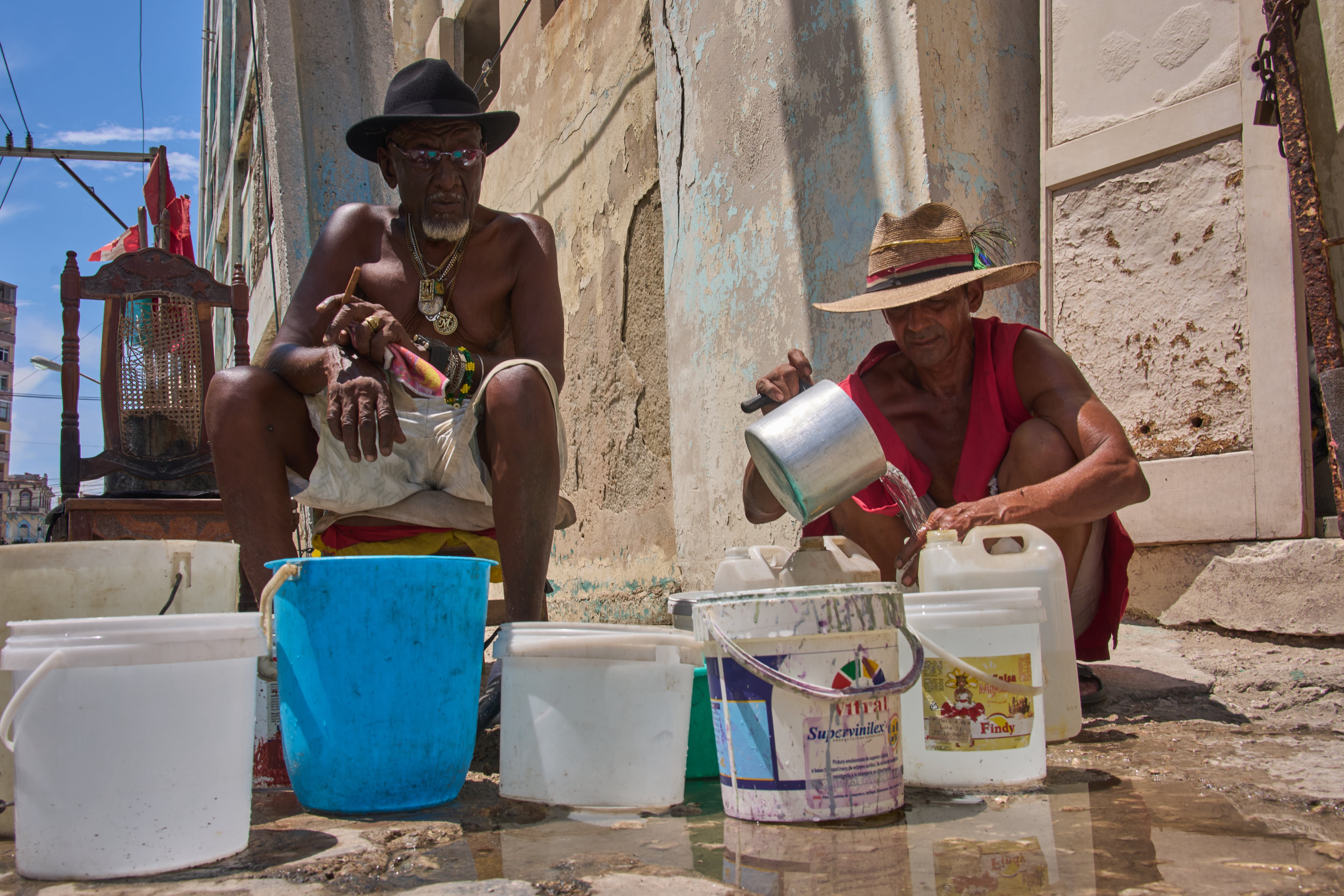 Oscar Joaquín López (izquierda) y su compañero de casa, Wilfredo Cisneros Duarte, recogen agua de una tubería en la calle en La Habana, Cuba, el 7 de septiembre de 2026. (AP Foto/Ramón Espinosa)