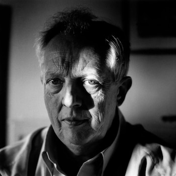 Retrato en blanco y negro de un hombre mayor con pelo canoso, rostro con arrugas y una sombra diagonal que cruza su cara