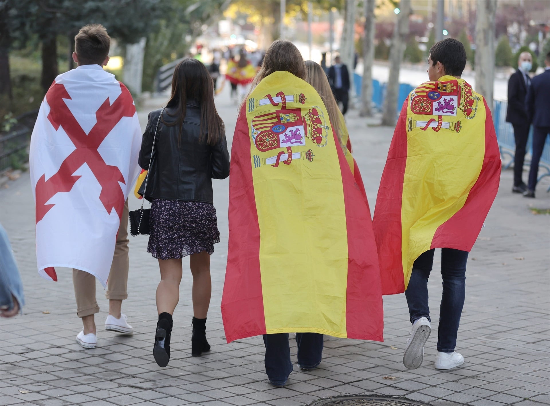 Un joven con la bandera de la Cruz de Borgoña y otros tapados con la bandera de España. (Eduardo Parra/Europa Press)