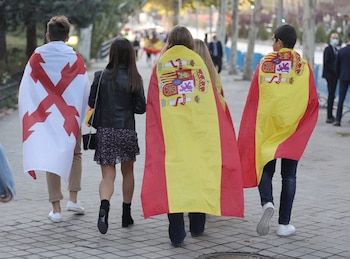 Un joven con la bandera de la Cruz de Borgoña y otros tapados con la bandera de España (Eduardo Parra / Europa Press)
