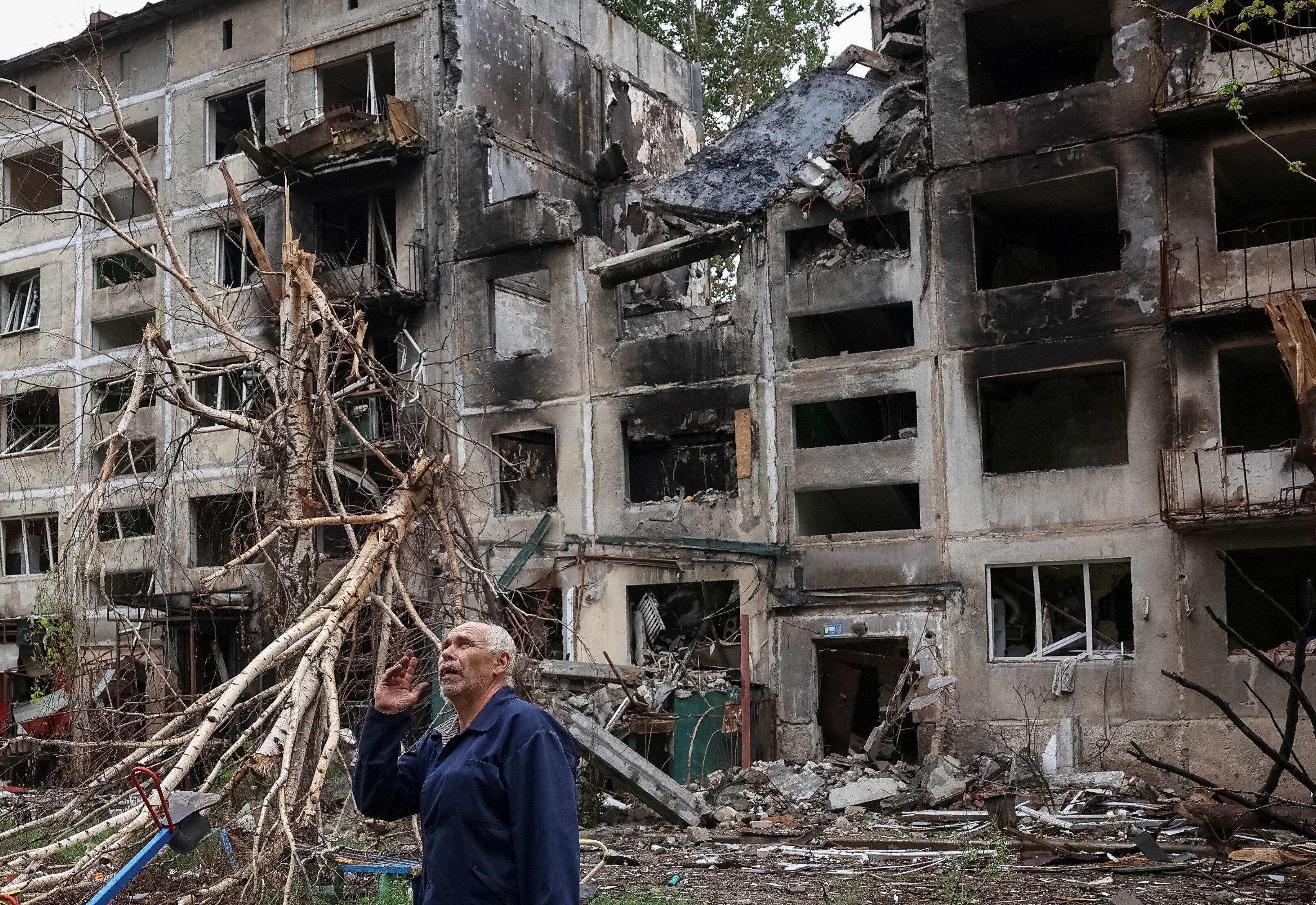 Un residente hace un gesto mientras se encuentra cerca de edificios dañados por los ataques militares rusos, en medio del ataque de Rusia a Ucrania, en la ciudad de primera línea de Myrnohrad, región de Donetsk, Ucrania (REUTERS/Anatolii Stepanov)