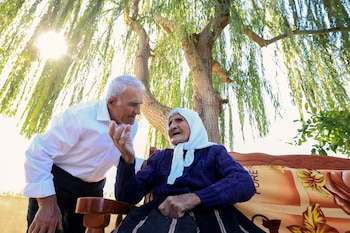 Qamile Marra, de 117 años, junto a su hijo Hysen Marra, de 80. (Adnan Beci/AFP)