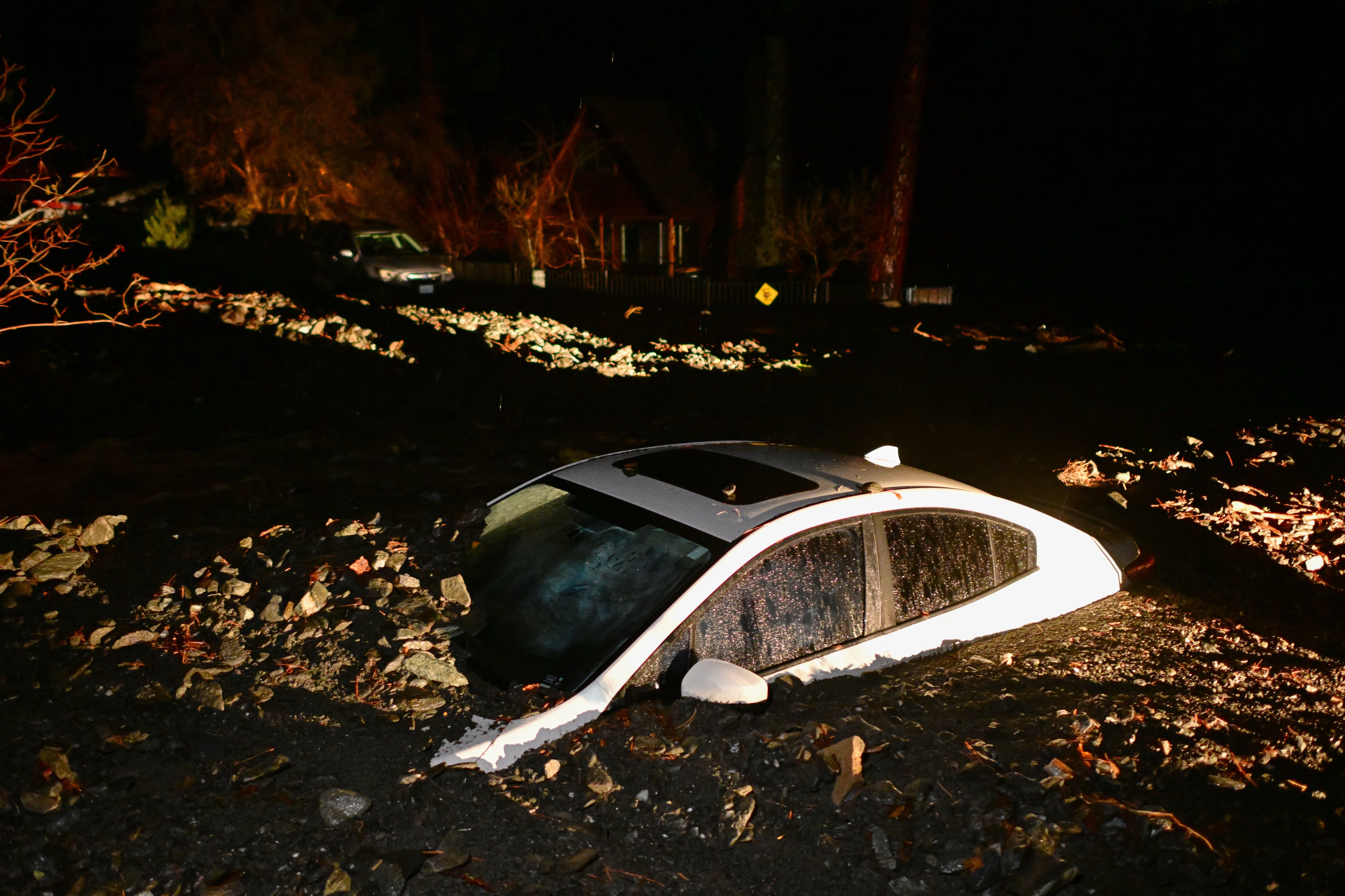 Un auto se ve enterrado en lodo tras una inundación el miércoles 24 de diciembre en Wrightwood, California, EE.UU. (AP Foto/Wally Skalij)
