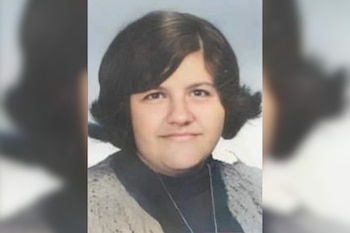 Retrato en primer plano de una mujer con cabello oscuro corto, que lleva una prenda oscura con cuello alto y un chaleco tejido