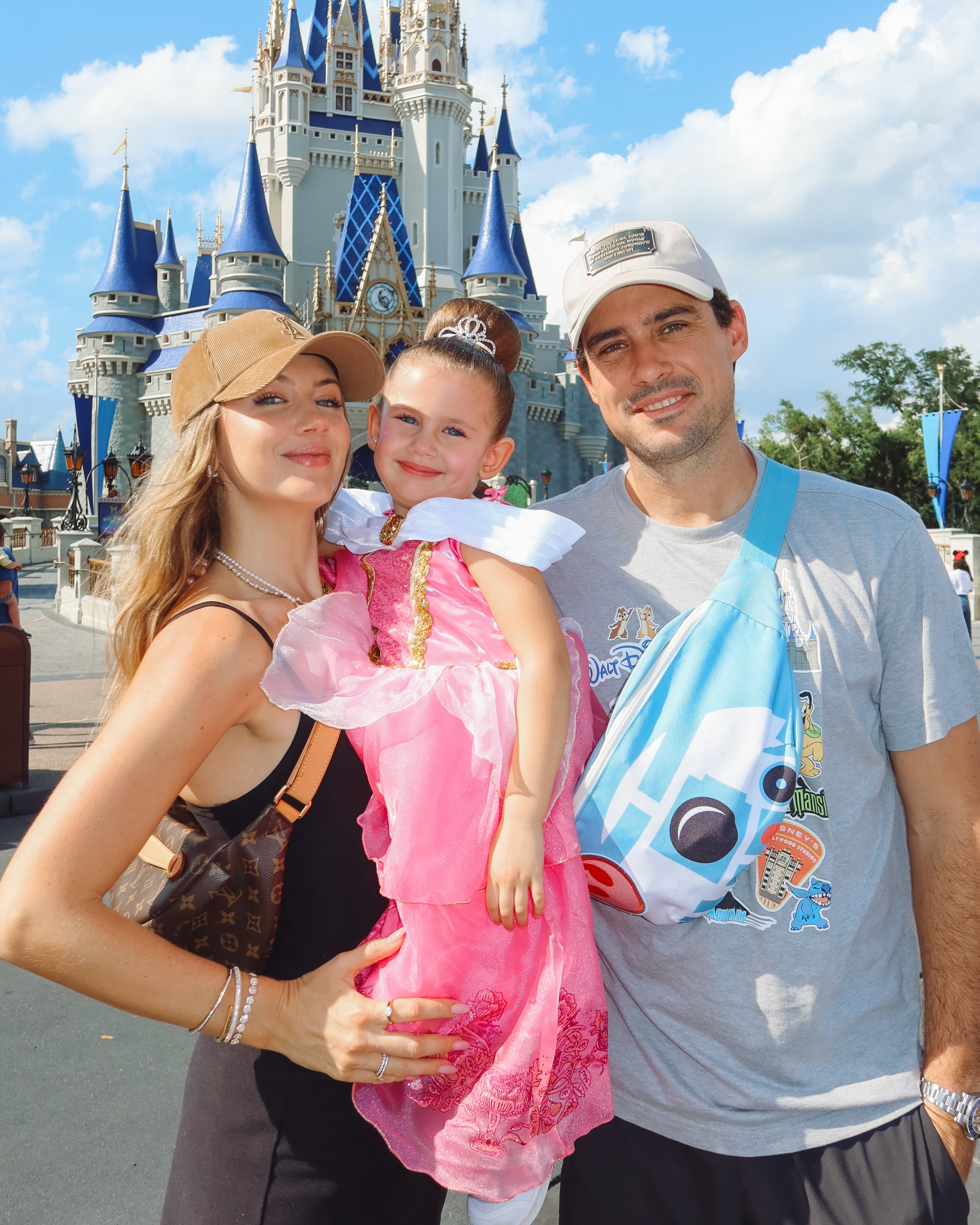Stephanie Demner, su hija Ariana vestida de princesa y su pareja posando frente al Castillo de Cenicienta en Walt Disney World, Florida
