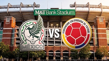 Escudos de fútbol de México y Colombia separados por el texto VS frente a la estructura exterior del estadio M&T Bank.