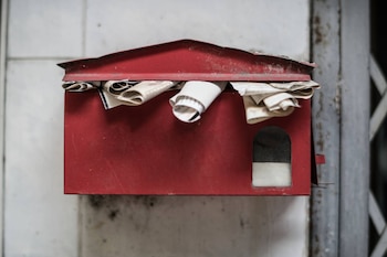 Un buzón lleno de cartas en un entorno rural.