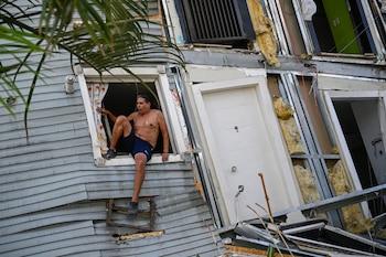 Un hombre en una ventana de una casa destruida en Catia La Mar