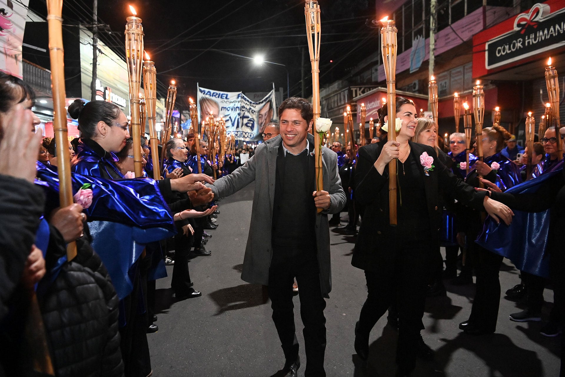 Kicillof con Mariel Fernández y las mujeres personificadas como Evita en la marcha de antorchas por las calles de Moreno