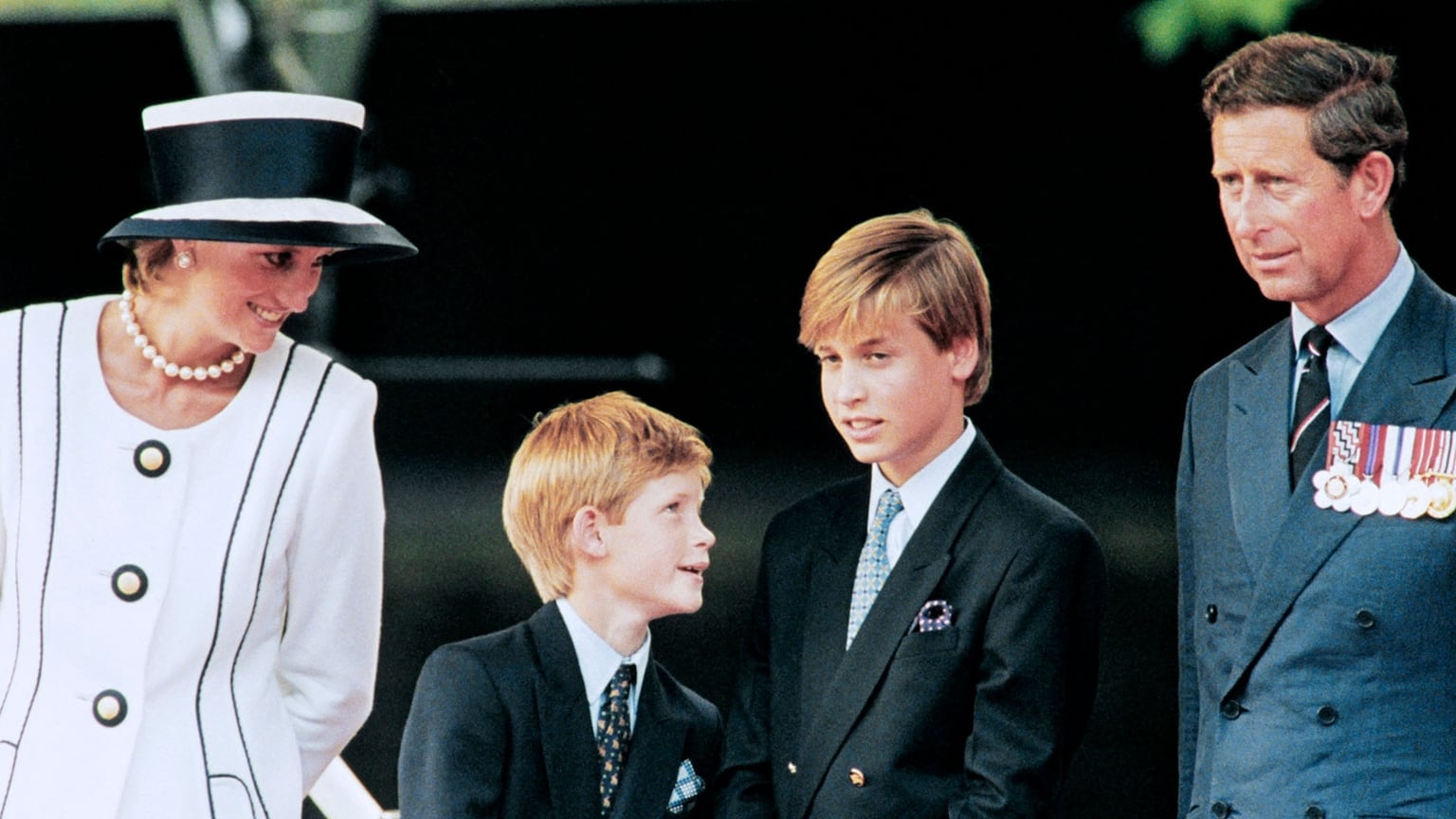 En esta foto de archivo tomada el 19 de agosto de 1995, el príncipe Carlos, la princesa Diana y sus hijos Guillermo y Harry observan el desfile desde una tarima en el National Mall, como parte de las conmemoraciones del Día de la Victoria sobre Japón. (Foto de Johnny EGGITT / AFP)