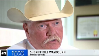 Primer plano de un hombre caucásico de mediana edad con bigote rubio y ojos azules, vistiendo un sombrero de vaquero blanco