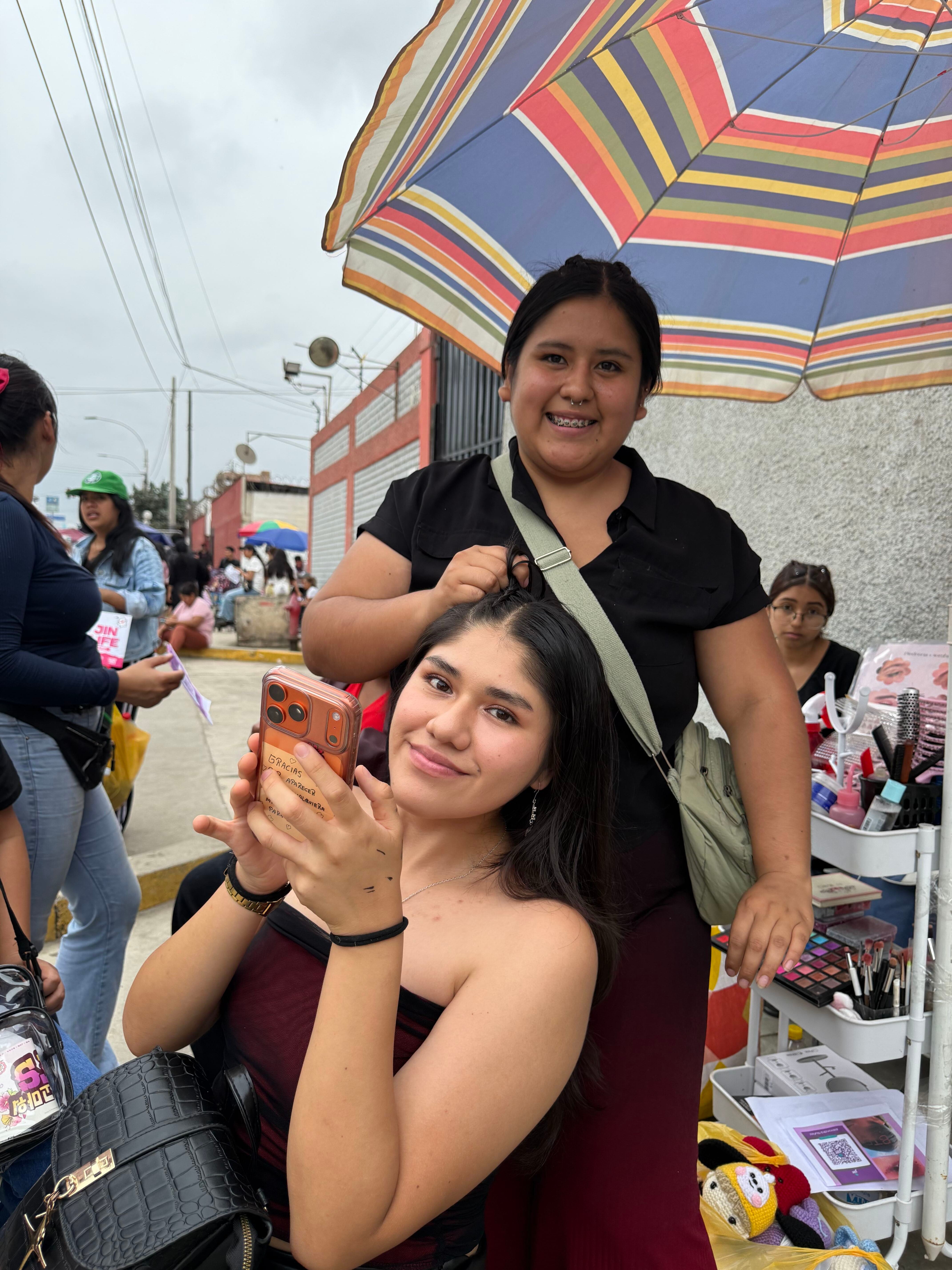 Seguidoras de la banda BTS arreglan su peinado en los exteriores del Estadio San Marcos antes de un concierto en Lima. (Paula Díaz)