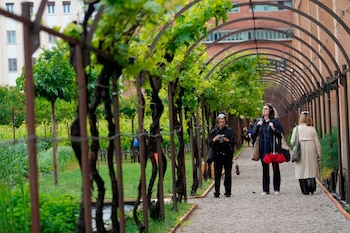 Visitantes disfrutan del pabellón del Vaticano "El oído es el ojo del alma", en los místicos jardines de las Carmelitas Descalzas, durante la Bienal de Arte, en Venecia (AP Foto/Luca Bruno)