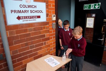 Niños se desinfectan las manos