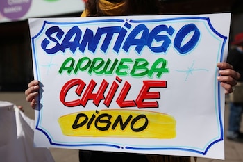 Una mujer sostiene una pancarta