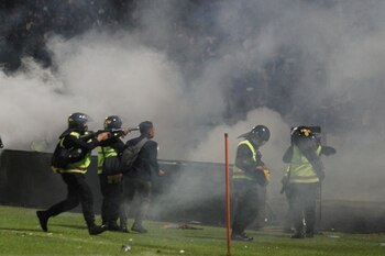 A riot police officer fires