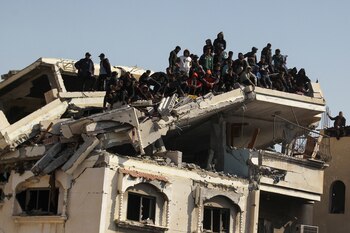 La gente se reúne en lo alto de un edificio dañado para ver la liberación.