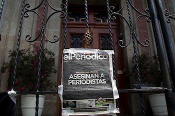ARCHIVO - Un ejemplar del periódico El Periódico de Guatemala que dice "Periodistas asesinados" cuelga en la puerta de la Casa Presidencial durante una protesta para exigir una investigación sobre el asesinato de dos periodistas y mayor seguridad para la profesión en la Ciudad de Guatemala, el 11 de marzo de 2015. Las publicaciones digitales de medios de comunicación centroamericanos serán resguardadas bajo un programa llamado Archivo Independiente de Medios de Centroamérica (CAIMA) financiado por la Agencia de los Estados Unidos para el Desarrollo Internacional (USAID) se anunció el miércoles 4 de diciembre de 2024. (Foto AP/Moises Castillo, Archivo)