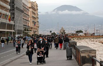 Personas caminan en el paseo marítimo de Nápoles. (REUTERS/Ciro De Luca)