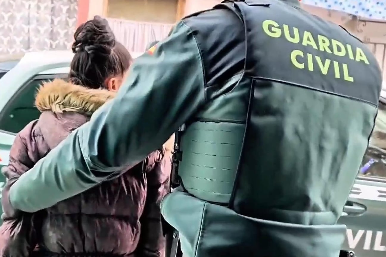 Un agente de la Guardia Civil dealoja a una mujer de una vivienda okupada. (Europa Press)