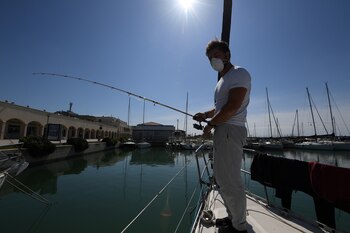 Una persona pescando con tapabocas