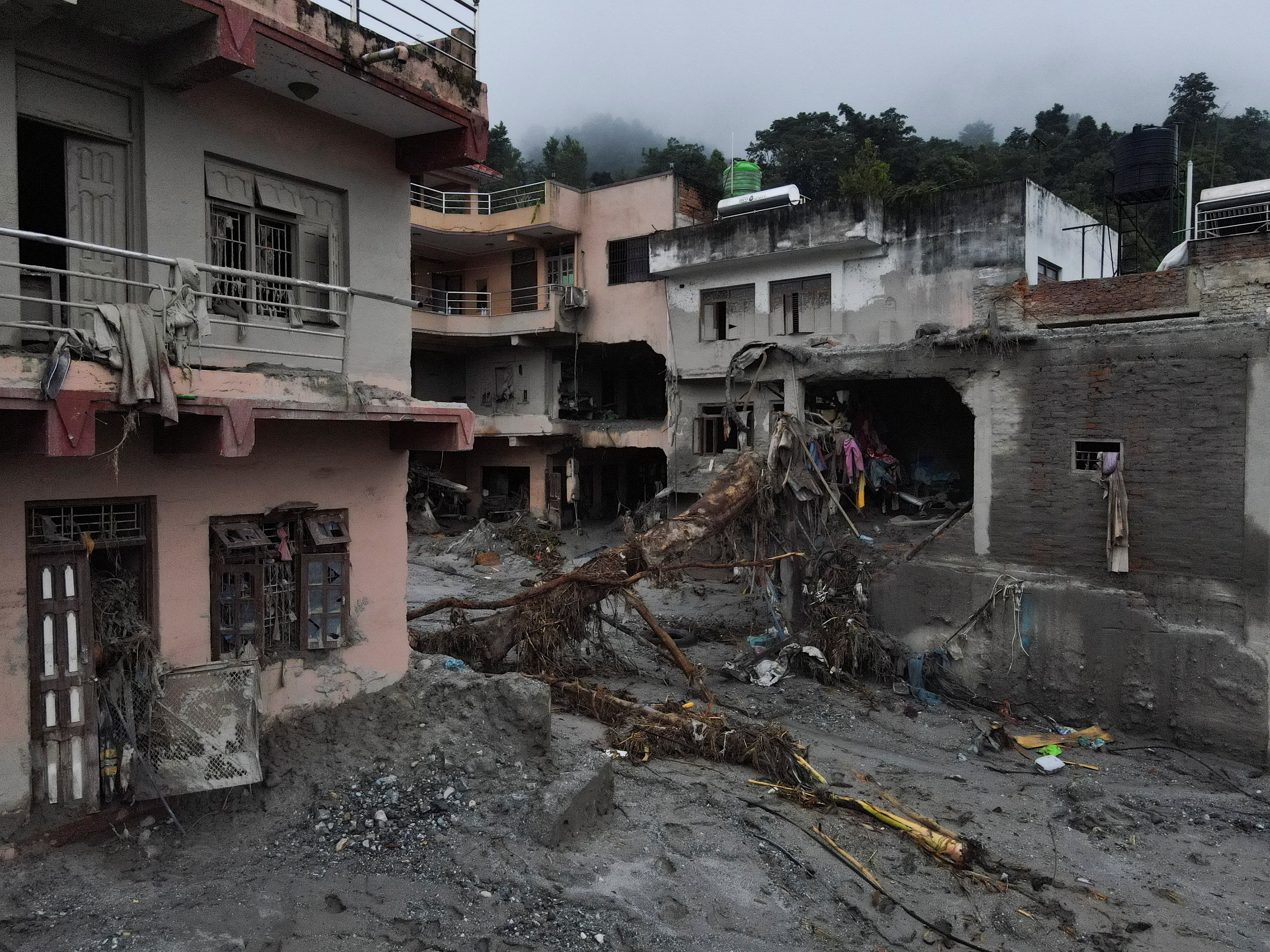 Imagen tomada desde un dron de un árbol arrancado de raíz y de viviendas dañadas tras las mortíferas crecidas repentinas y un deslizamiento de tierra, en Devighat, distrito de Nuwakot, Nepal, el 31 de agosto de 2026. REUTERS/Francis Mascarenhas
