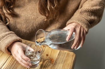 Una mujer sirviéndose agua (Magnific)