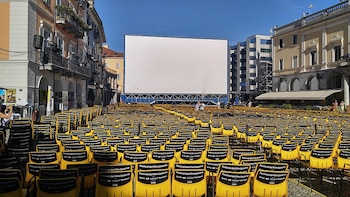 Una pantalla blanca al fondo y sillas desplegadas delante de ella para ver las películas.