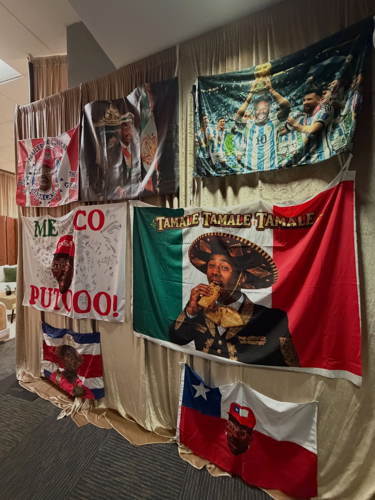 Diversas banderas diseñadas por fans de Tyler, The Creator, combinando su imagen con motivos mexicanos, argentinos, costarricenses y chilenos, son exhibidas en un evento, reflejando el impacto cultural del artista. (Instagram/bigdaddykelly)