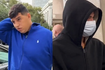 Un hombre vestido con sudadera azul junto a otro individuo con sudadera negra, capucha puesta y mascarilla médica