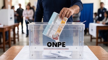 Una mano introduce una cédula de sufragio doblada en la ranura de una urna transparente con el logotipo de la ONPE.
