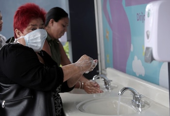 Una mujer usa una máscara