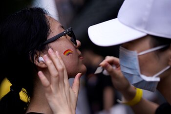 Una chica se pinta el rostro con los colores del arcoíris para participar en una actividad del Gay Pride en China