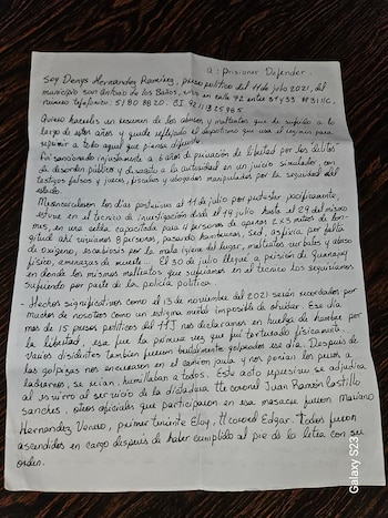 Hoja de papel blanco con texto manuscrito en tinta negra colocada sobre una superficie de madera oscura