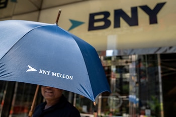FILE PHOTO: A person holds an umbrella with the logo of BNY Mellon near the offices of BNY Mellon investment banking company in New York City, U.S., July 10, 2024.REUTERS/David 'Dee' Delgado/File Photo
