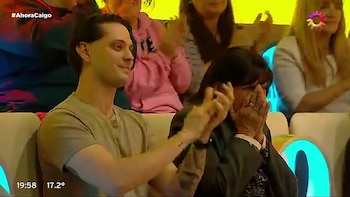 Una mujer se cubre el rostro con ambas manos sentada junto a un hombre que aplaude entre los espectadores de un estudio de televisión