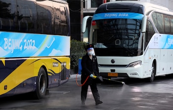 A staff member disinfects the yard of a media hotel inside a closed loop area designed to prevent the spread of the coronavirus disease (COVID-19) ahead of the Beijing 2022 Winter Olympics, in Beijing, China January 14, 2022. REUTERS/Fabrizio Bensch