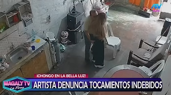 Captura de pantalla: hombre abrazando a mujer por la cintura en un interior. En la parte inferior, texto que lee 'Magaly TV, ARTISTA DENUNCIA TOCAMIENTOS INDEBIDOS'