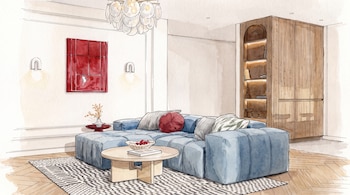 Ilustración de sala de estar con sofá seccional azul, mesa de centro de madera, alfombra, cuadro rojo, dos apliques de pared, candelabro y gabinete de madera.