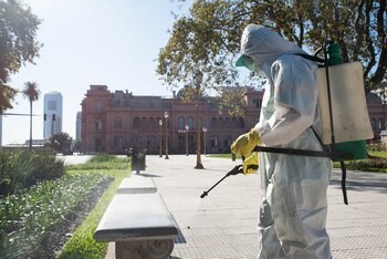 Un hombre desinfectando un banco