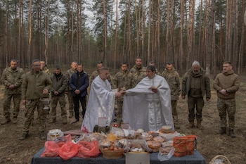 Capellanes oran junto a militares de la 33ª brigada mecanizada durante las celebraciones de Pascua ortodoxa en la región de Járkov. Por primera vez en mucho tiempo, esa noche no se registraron ataques rusos con drones Shahed ni misiles. (Roman PILIPEY / AFP)