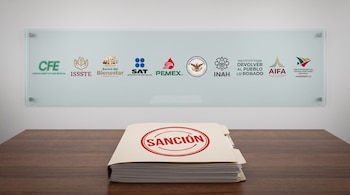 Un expediente con un sello rojo que dice Sanción sobre una mesa de madera frente a un panel con logotipos de dependencias de México.