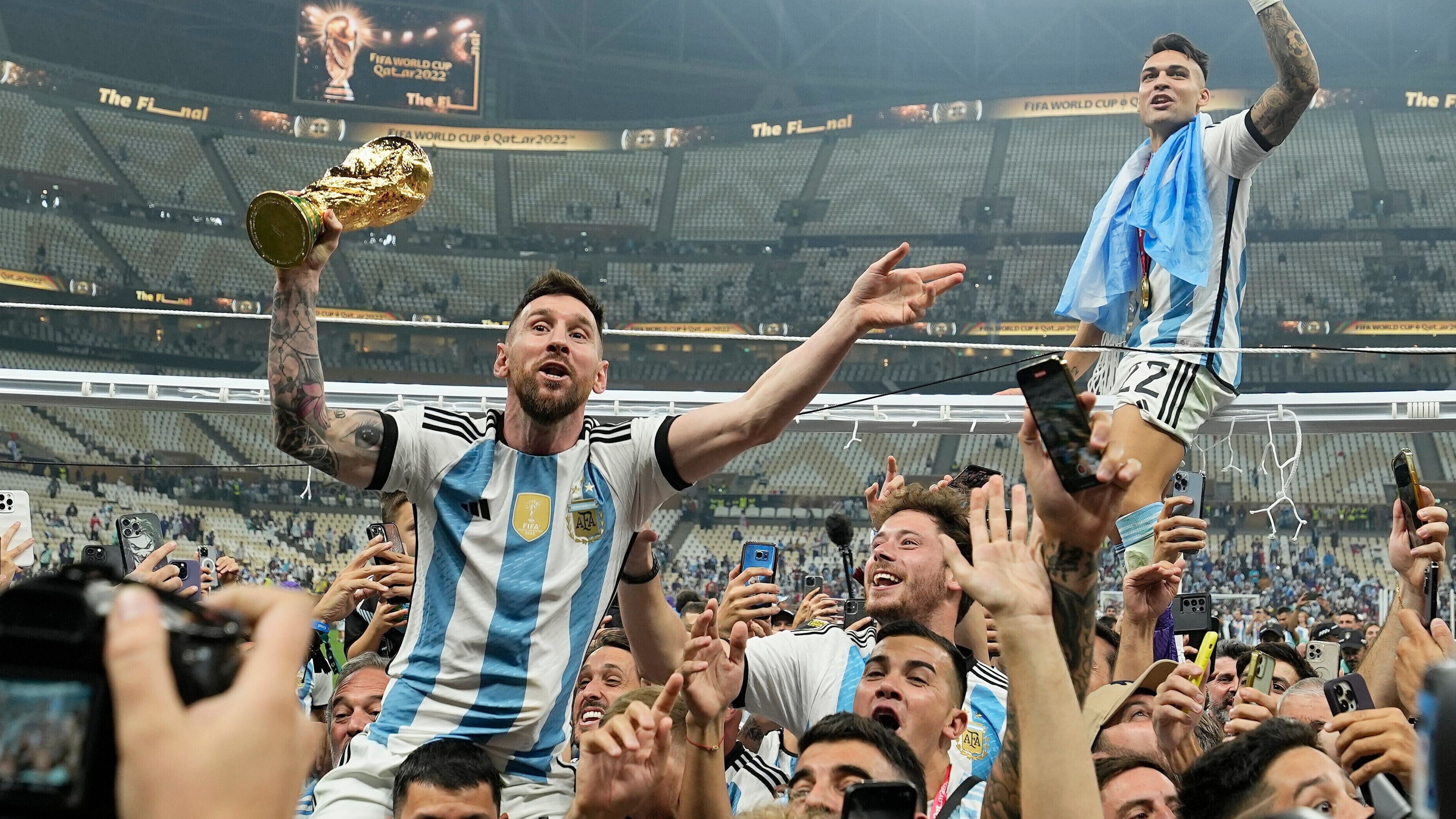FILE - El capitán de Argentina, Lionel Messi, celebra con el trofeo entre fanáticos tras ganar la final de la Copa del Mundo ante Francia en Lusail, Qatar, Dic. 18, 2022. (AP Foto/Martin Meissner, File)